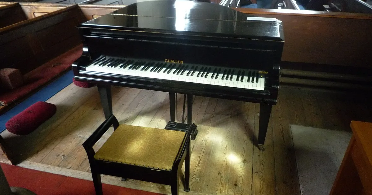 Piano de cola negro con su banqueta junto a los bancos de madera de la iglesia de San Pedro de Lugwardine (Inglaterra), en abril de 2019 (imagen ilustrativa; no guarda relación con los artistas ni con la grabación)